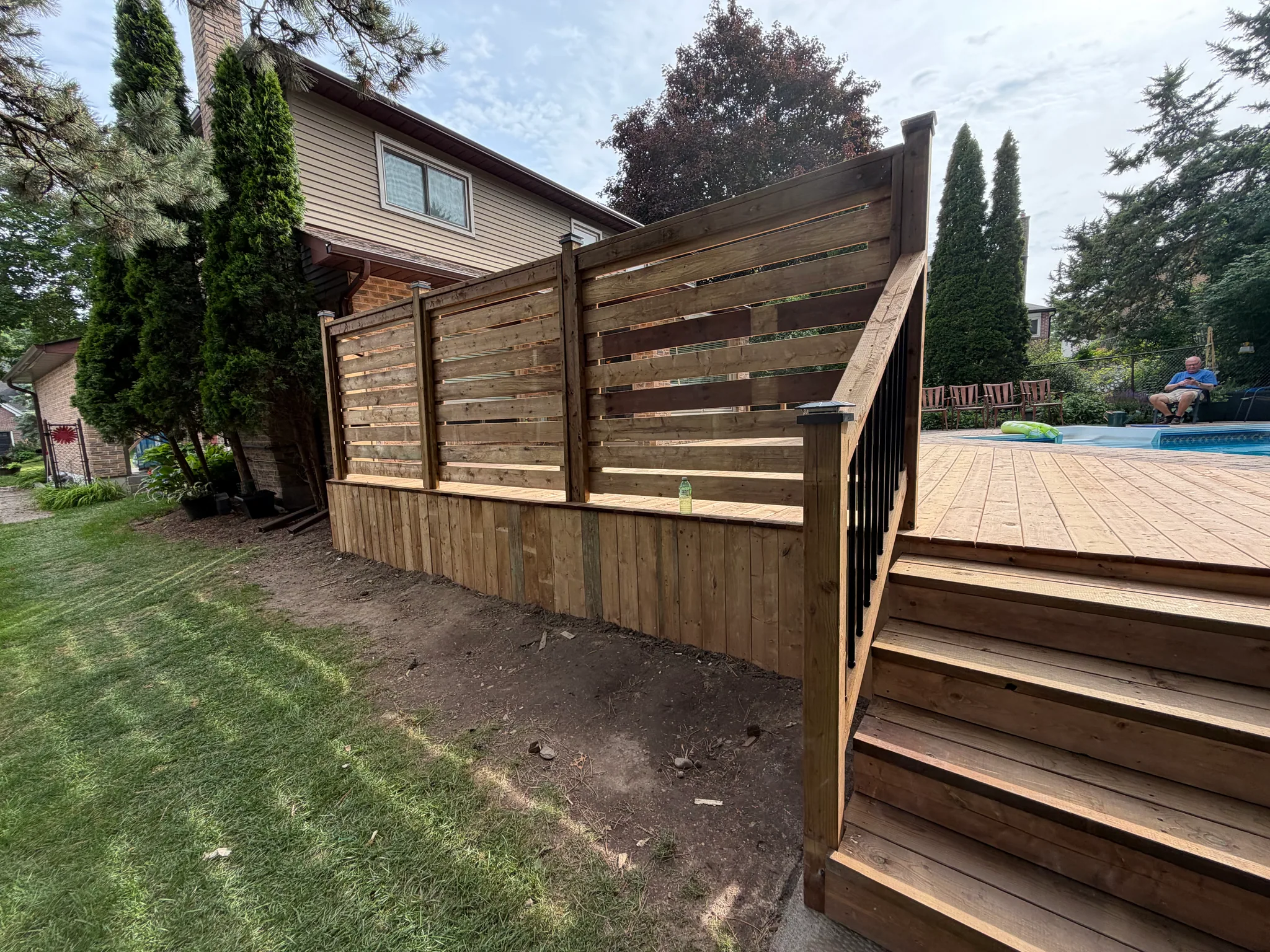 Deck stairs beside a wood privacy screen