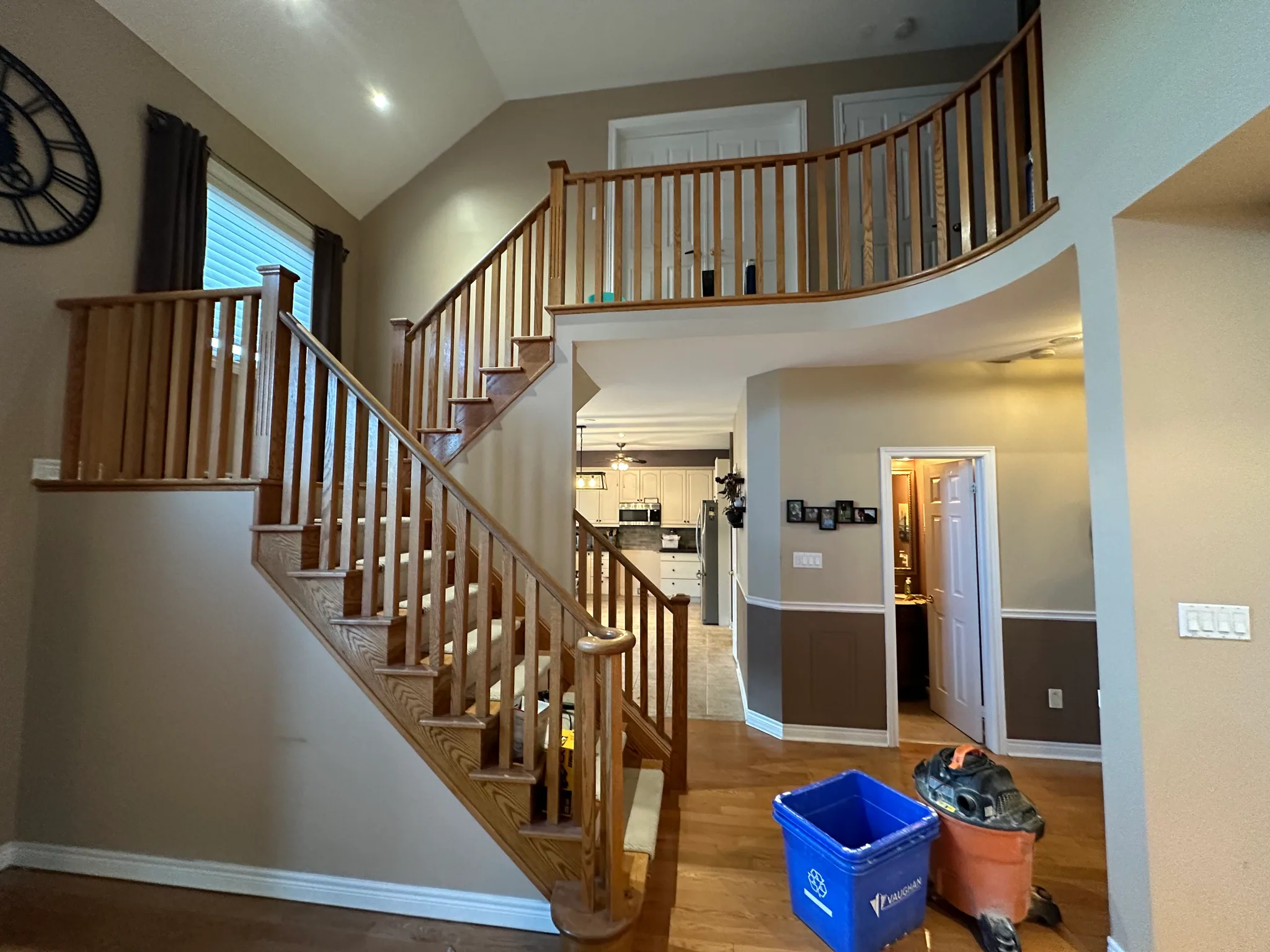Staircase with carpet and wood railing before refinishing