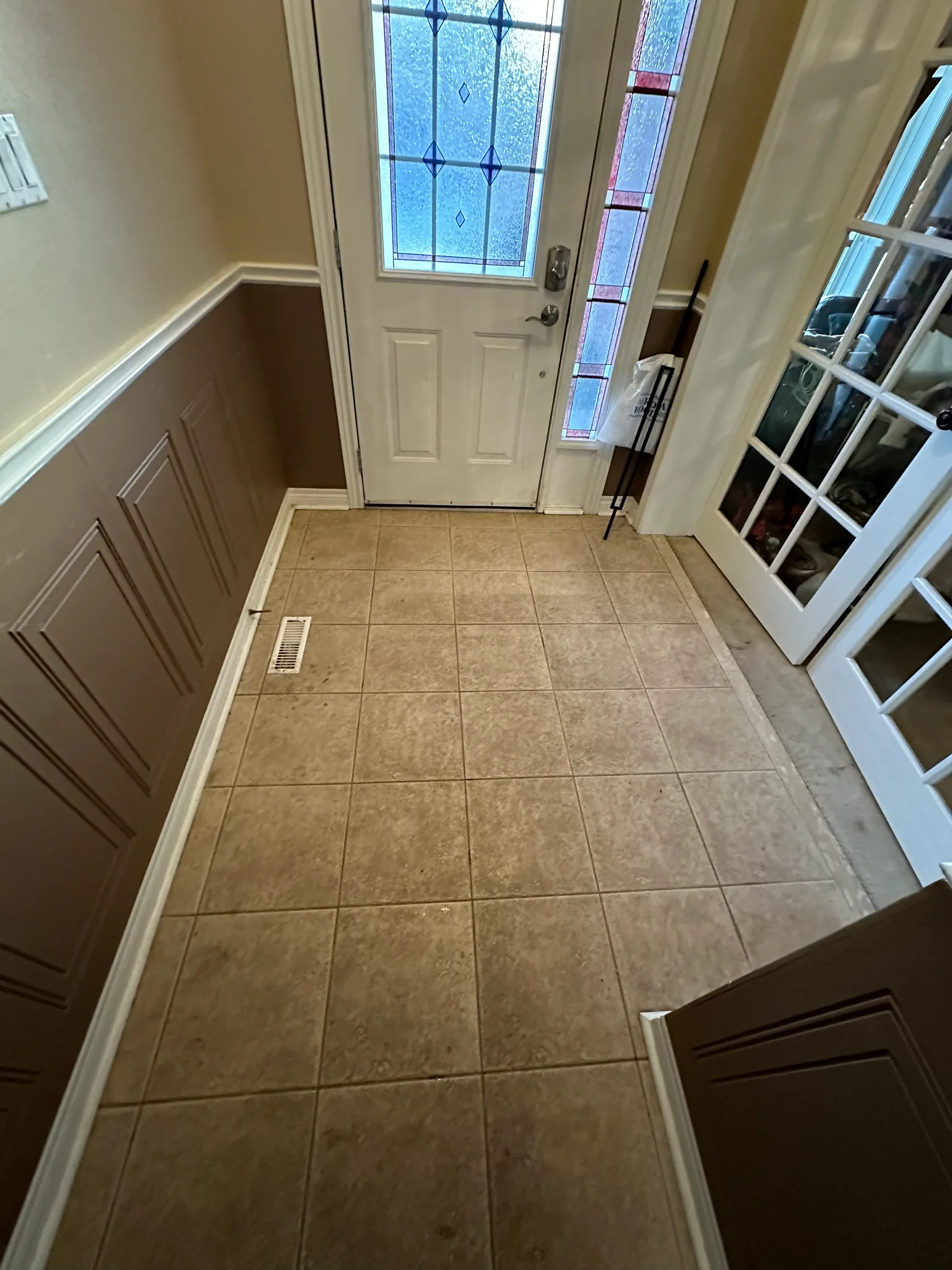 Square beige floor tiles in a front entryway