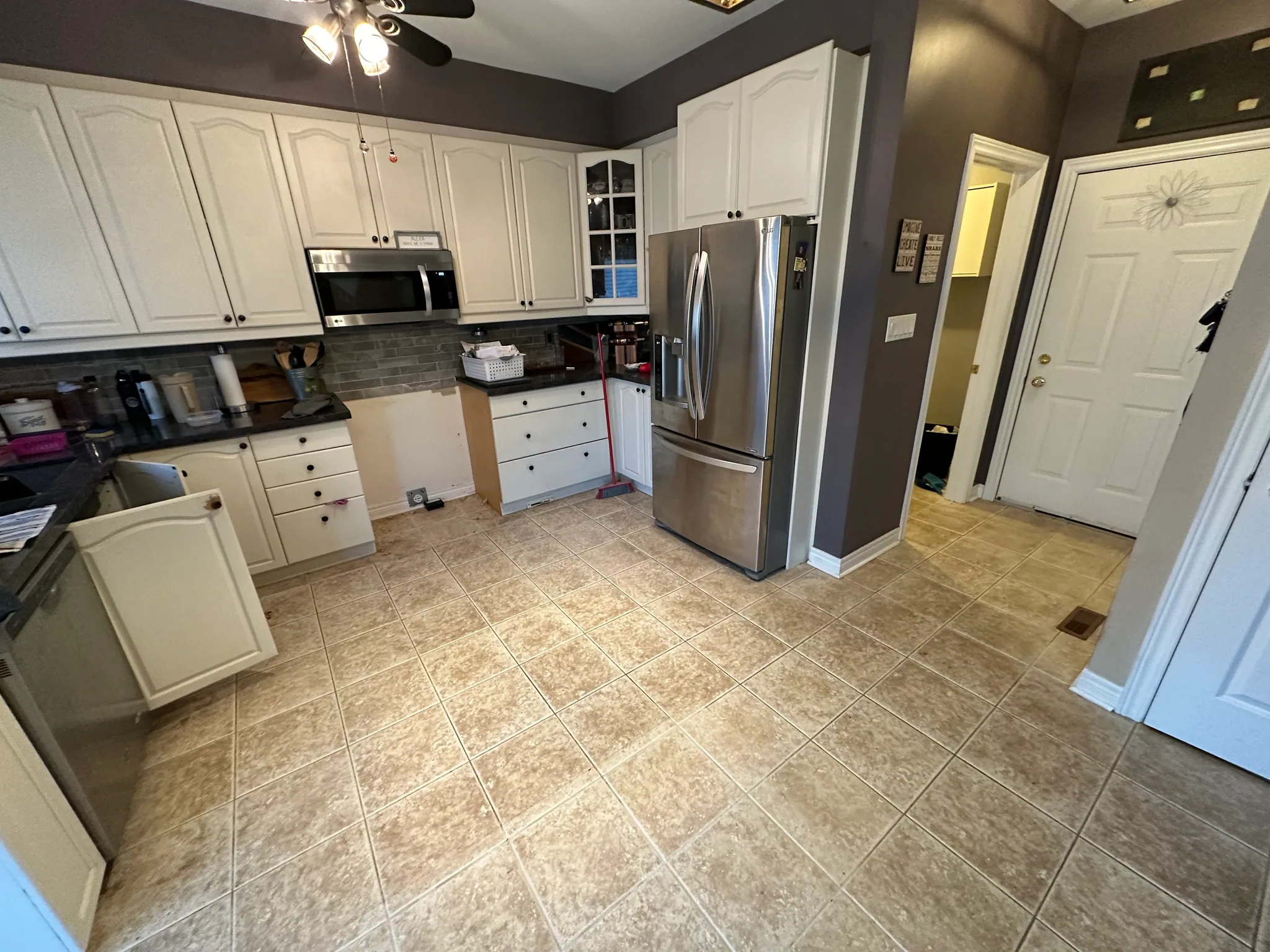 Square kitchen floor tiles around white cabinets